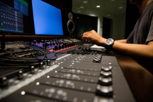 A music producer remixing music in a sound studio.