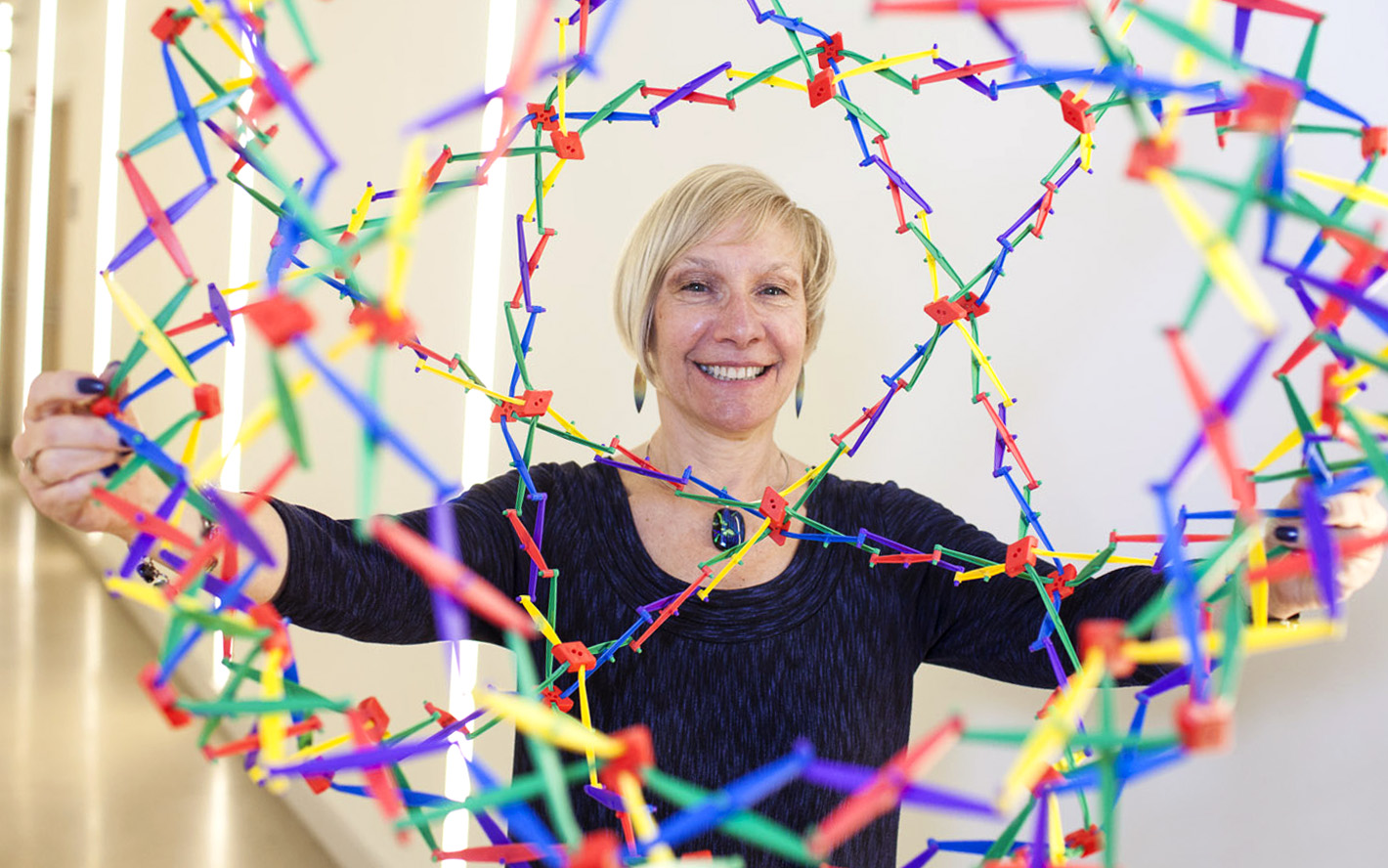 Music therapist Dr. Suzanne Hanser is shown playing with a colorful object.