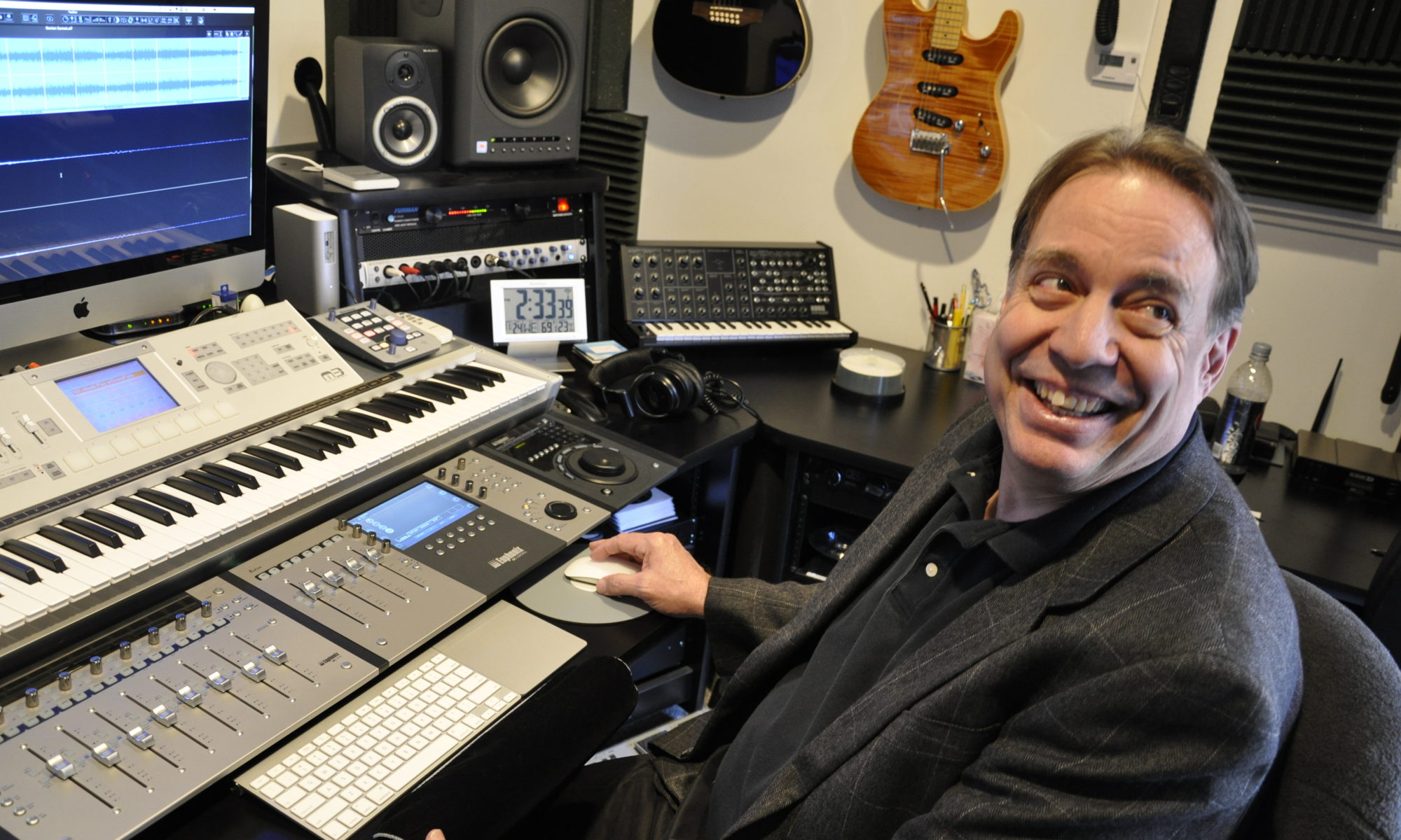 Peter Bell sits at a sound board creating commercial music.