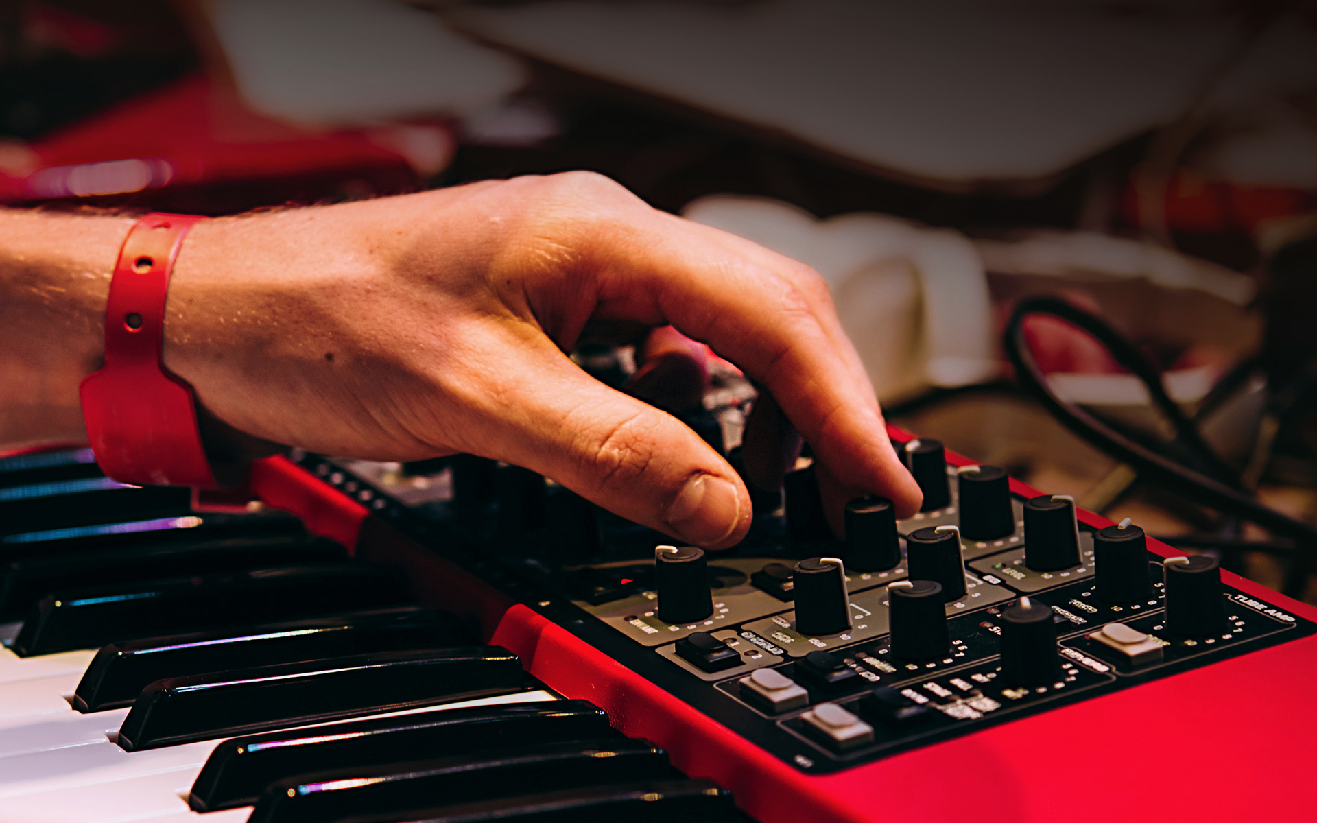 An electronic musician composing house music on a synthesizer.