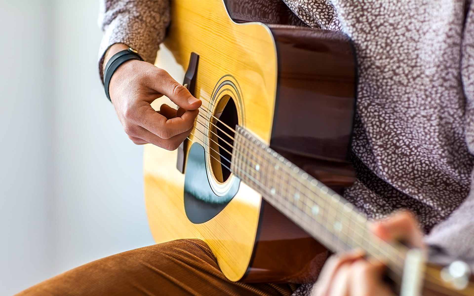 A person playing acoustic guitar.