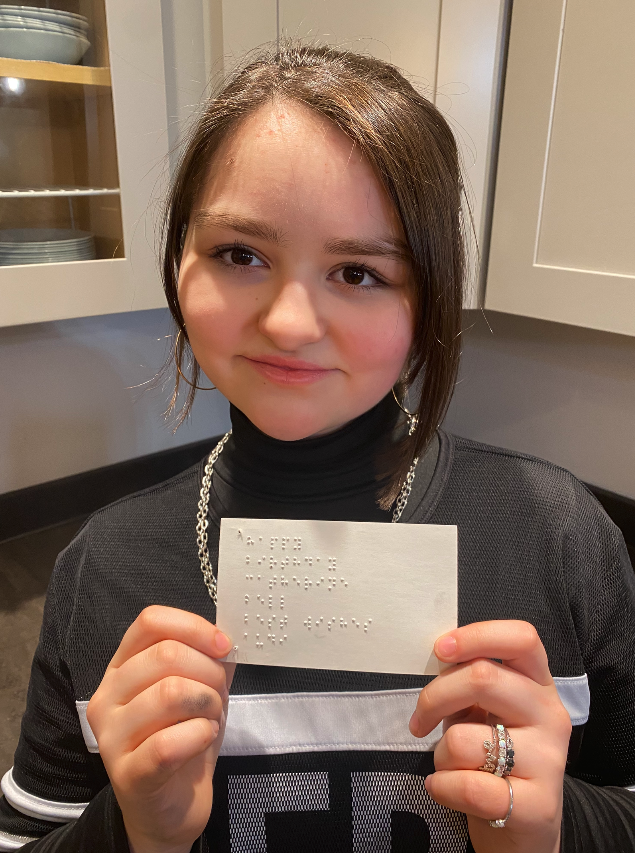 Audi holding up a Braille birthday card.