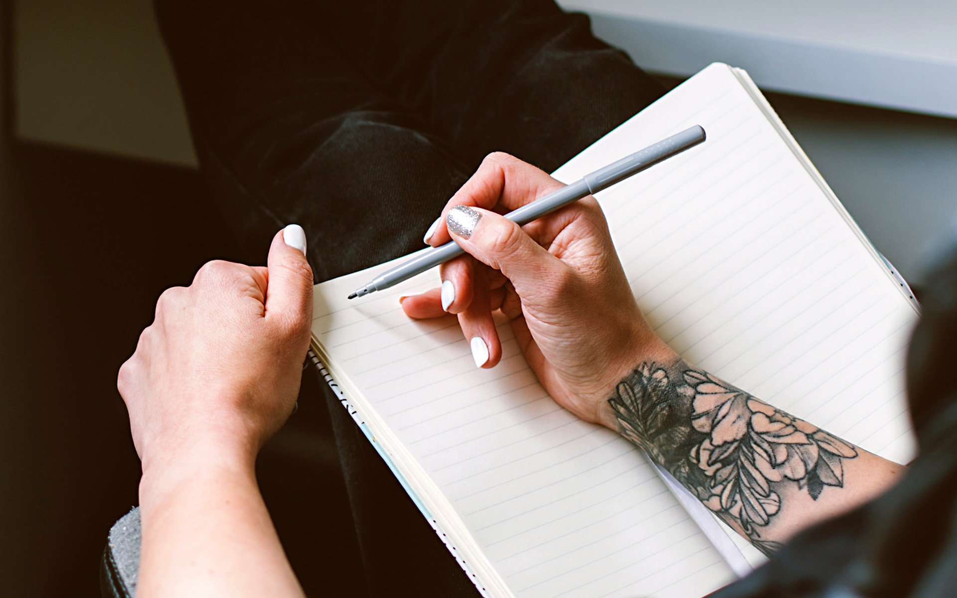 person writing a song in a notebook