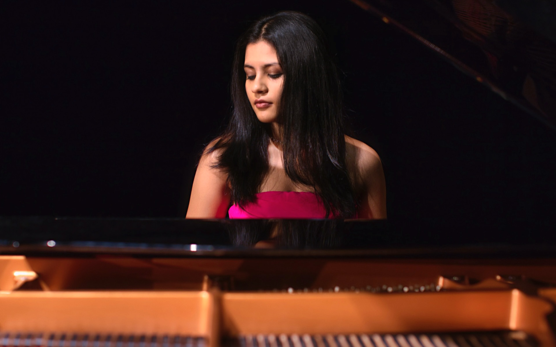 Aarya Mehta sits at her piano.