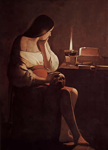 In "Mary Magdalene with a Night Light" by Georges de la Tour, a woman with long, dark brown hair is looking into a flame, which sits on a desk with old books on the surface. She has a human skull on her lap.
