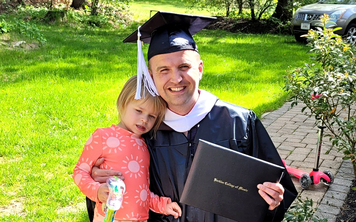 Berklee Online advisor and graduate Eric Zawada gives his daughter a hug on Graduation Day, 2023.