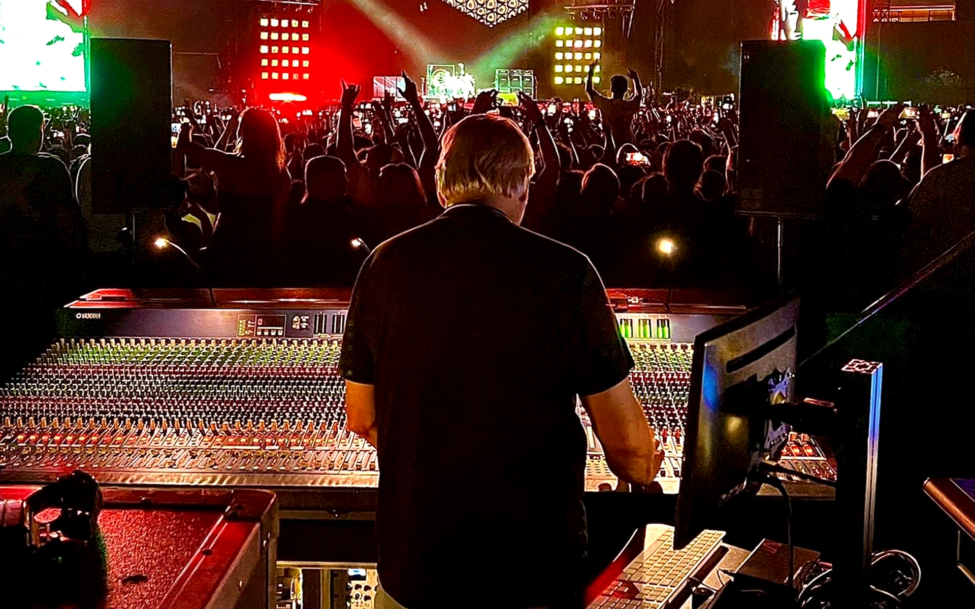 Sound engineer Toby Francis stands at the console, mixing front of house for the Red Hot Chili Peppers.