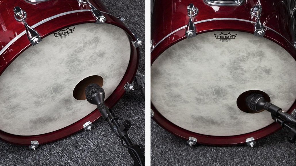A microphone is pictured just outside of a bass drum.