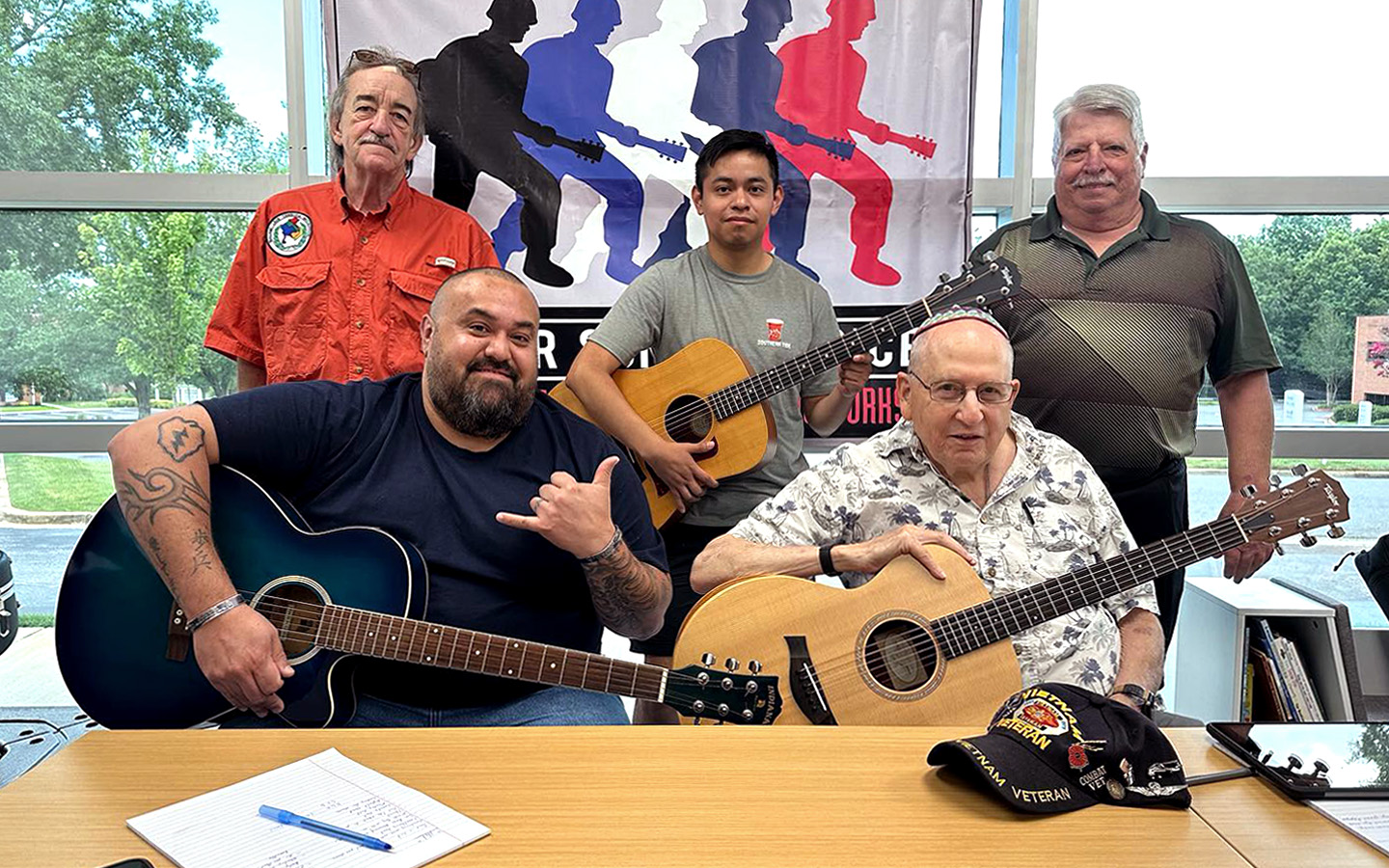 A group of United States war veterans—including Phil Schwartz and John Gerac—poses for a photo after participating in a Soldier Songs and Voices event.