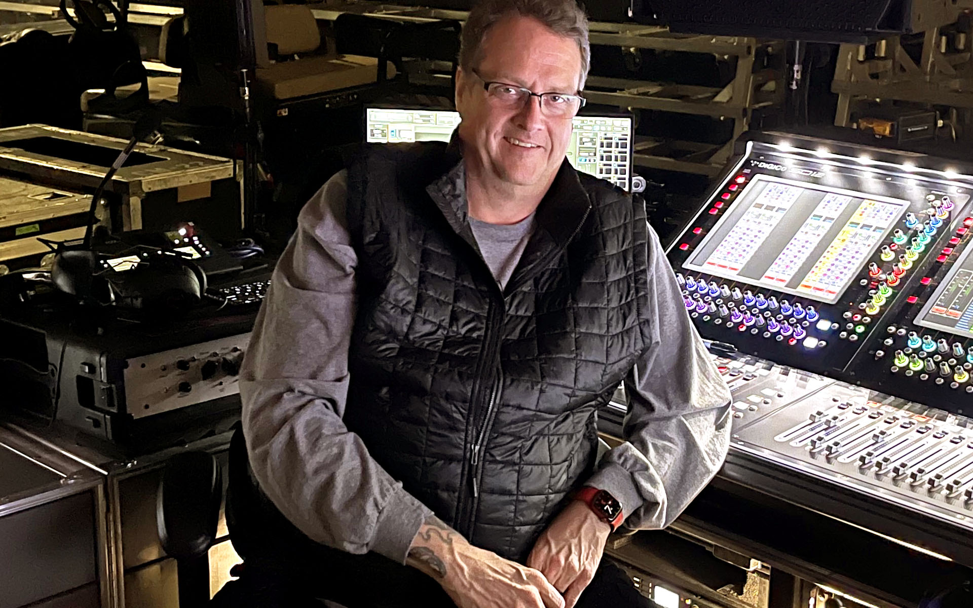 Live sound engineer Ken “Pooch” Van Druten is pictured sitting behind a mixing console.
