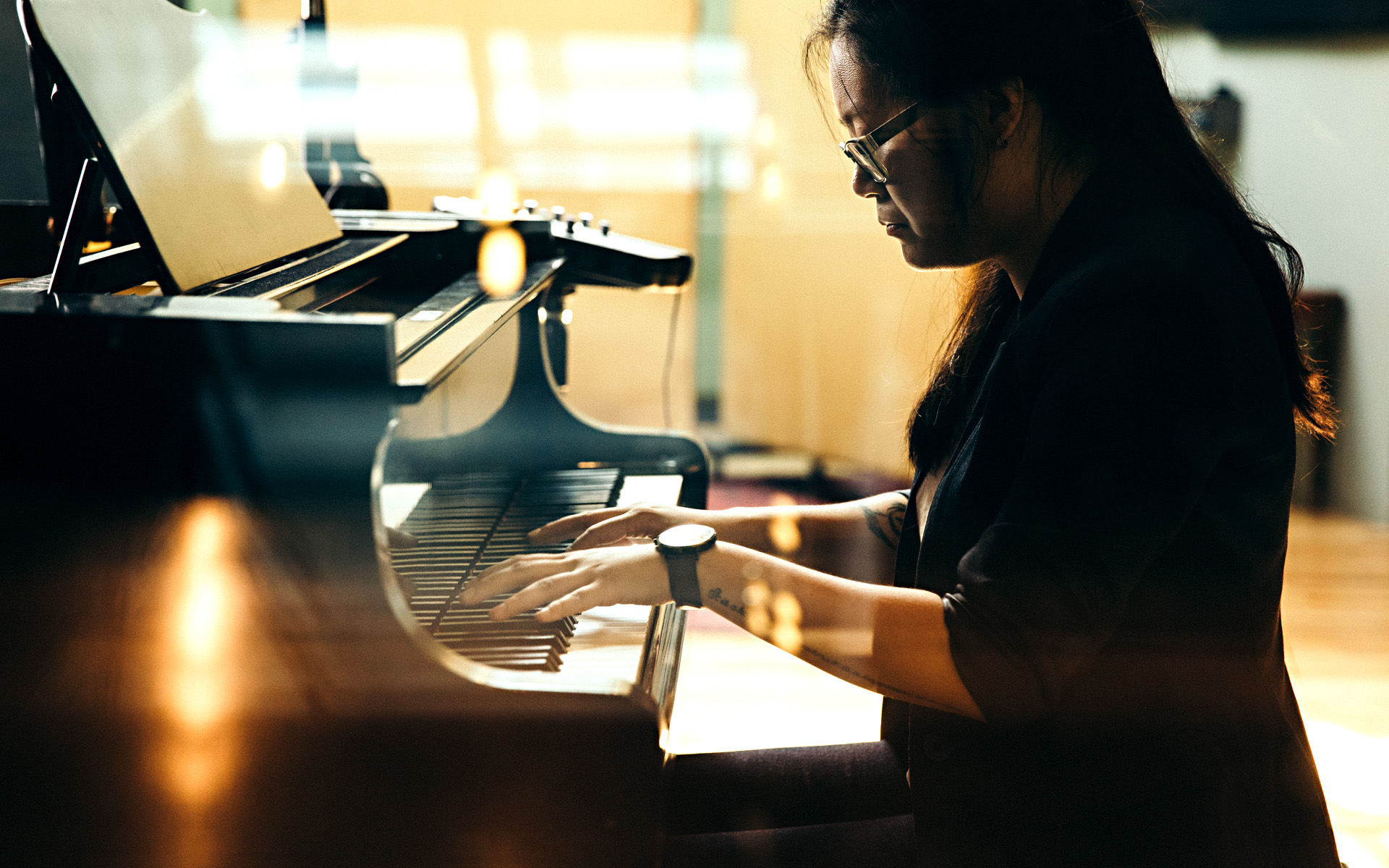A woman plays piano, hypothetically working out major and minor modal scales.