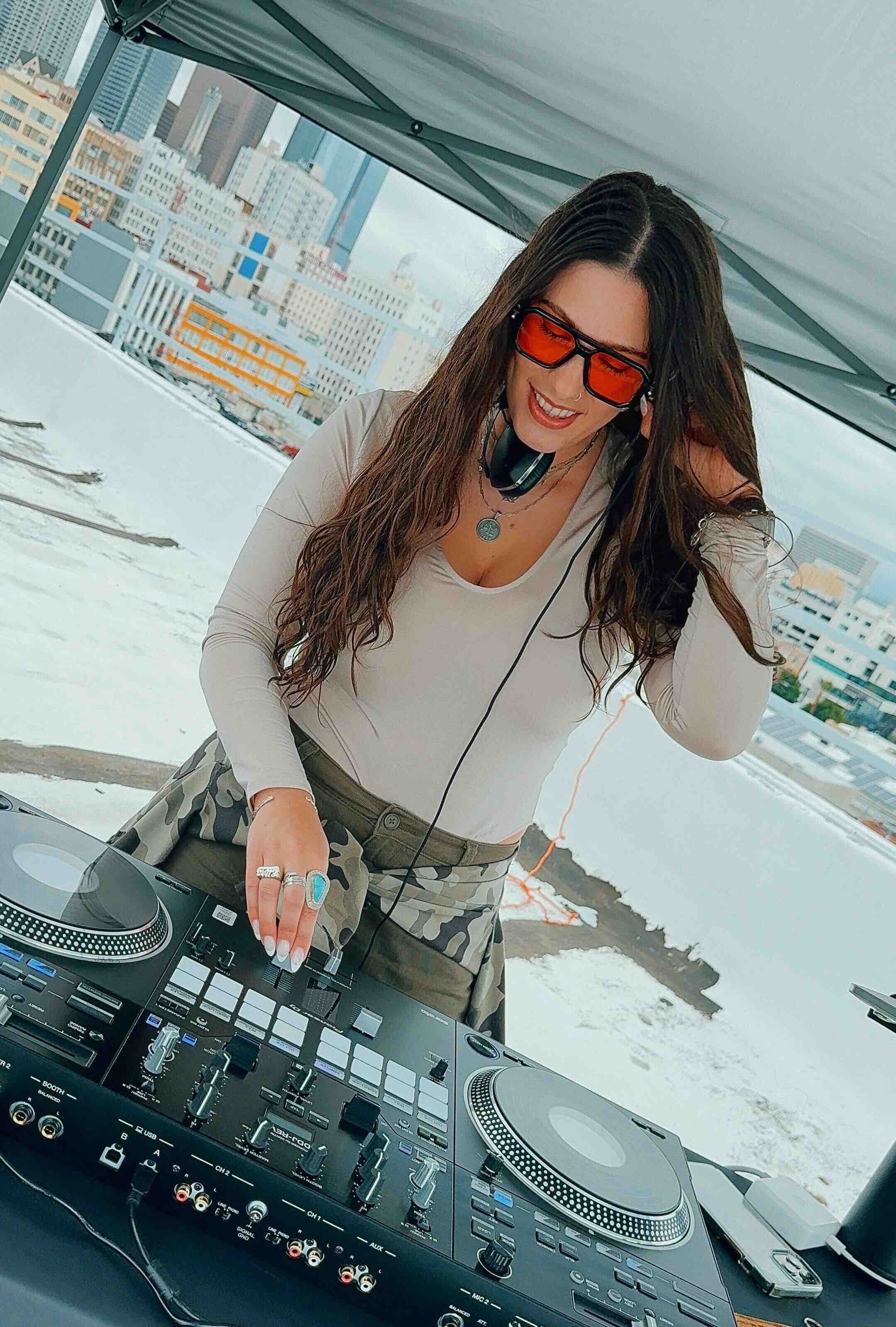 Freesia DJing at a booth with her laptop and controller