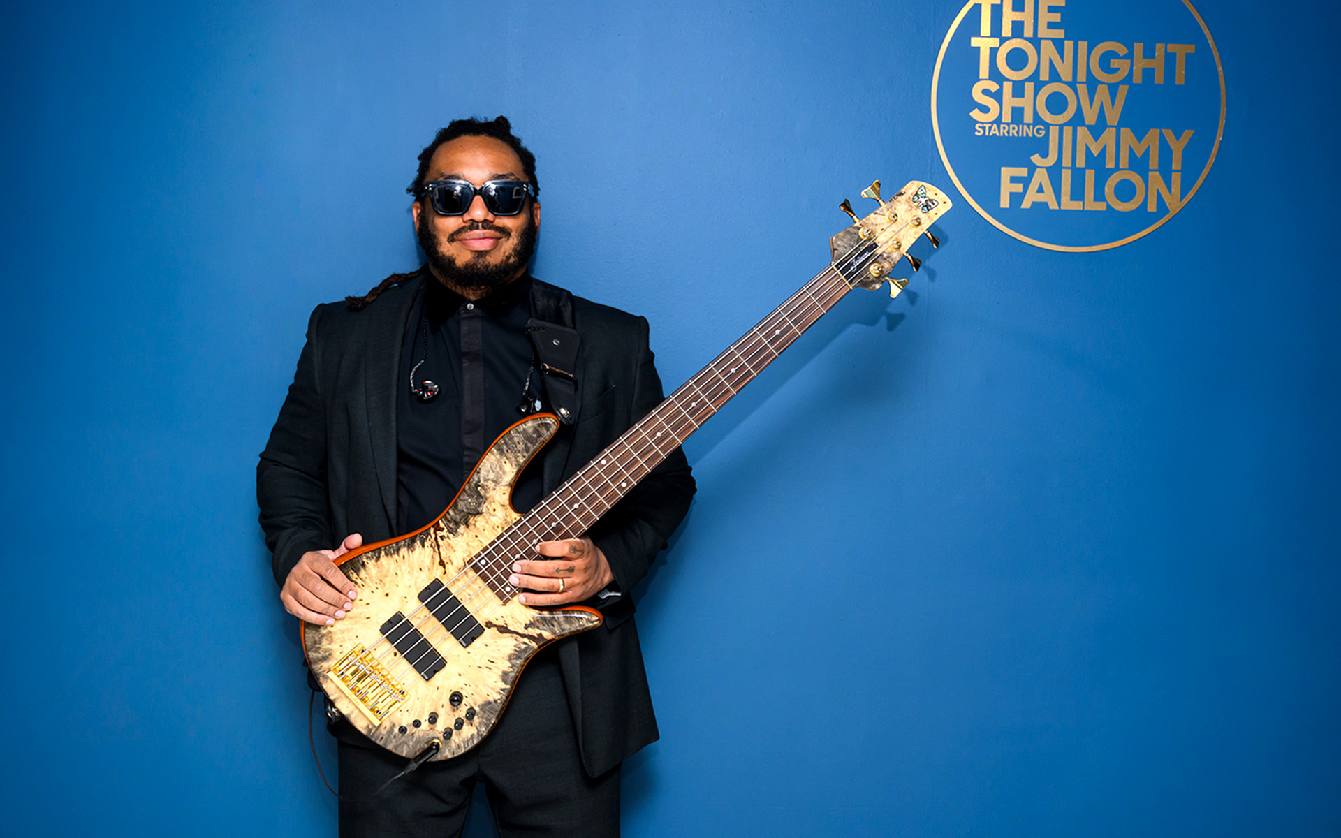 Mark Kelley of The Roots stands in front of the logo for his employer, The Tonight Show Starring Jimmy Fallon.