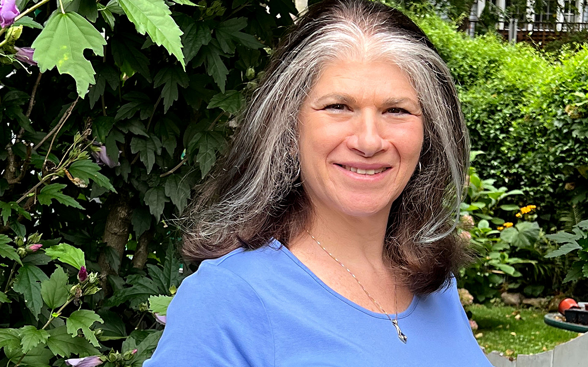 Lori Landay in front of a backdrop of foliage