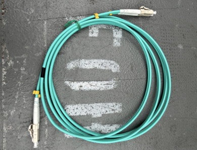 A screen grab of a green optical MADI cable is pictured on a grey background