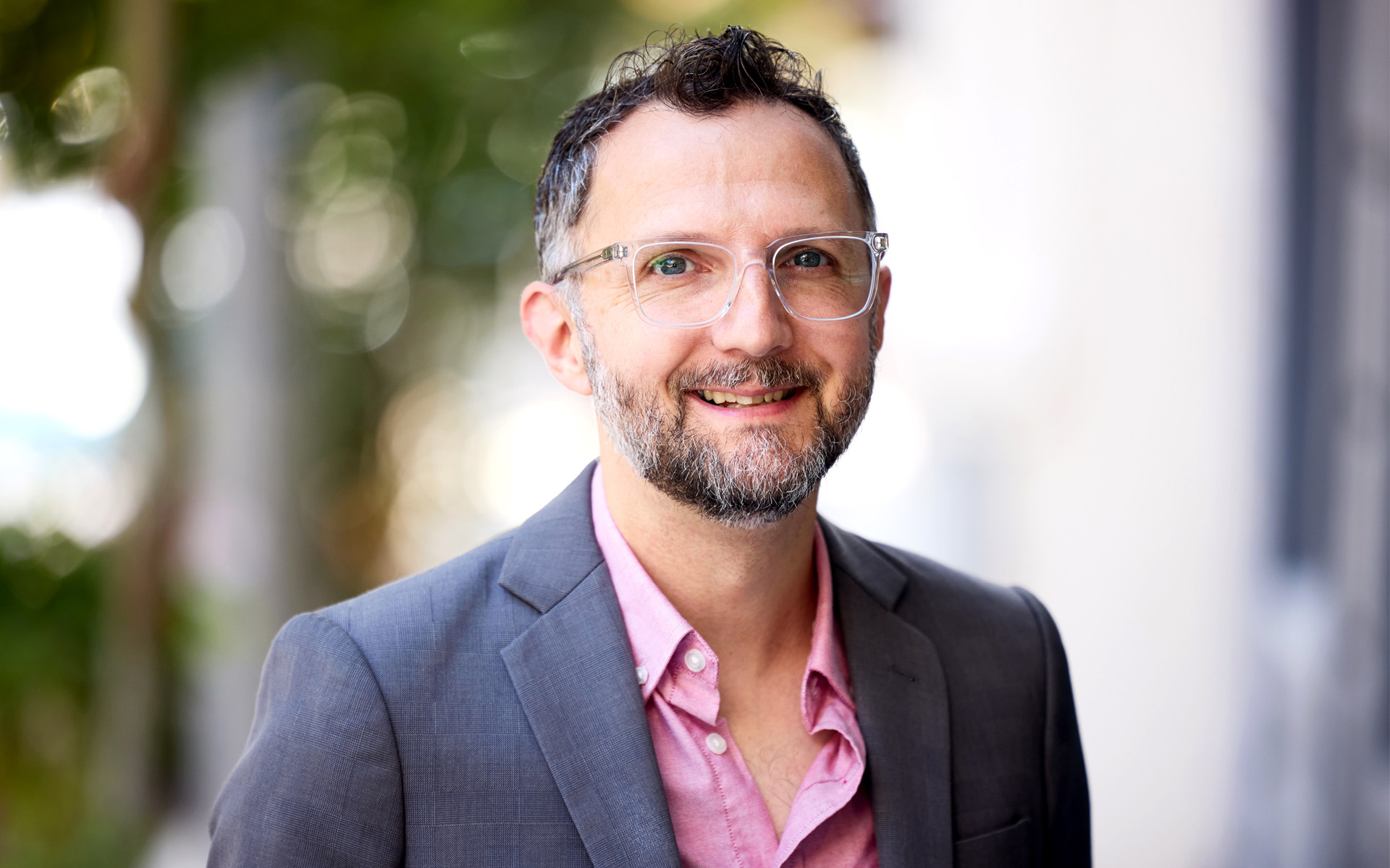 A photo of Mark Ethier, Executive Director of Berklee Emerging Artistic Technology Lab ( also known as BEATL), where he is wearing a pink shirt and a gray sports coat.