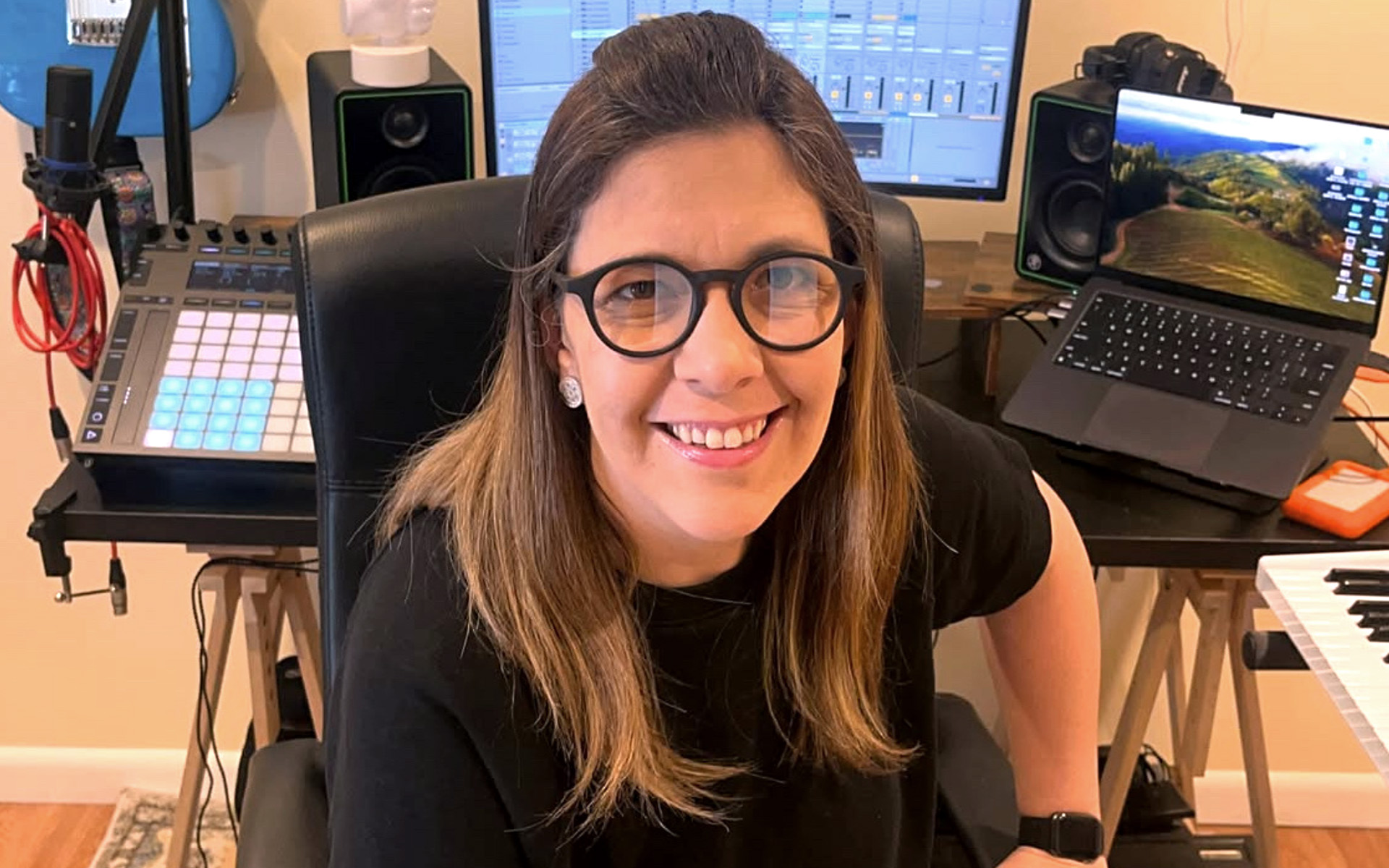 Photo of Luana Bittencourt, a Berklee Online student, and winner of the Women in Vinyl scholarship, sitting in front of her home recording studio gear.