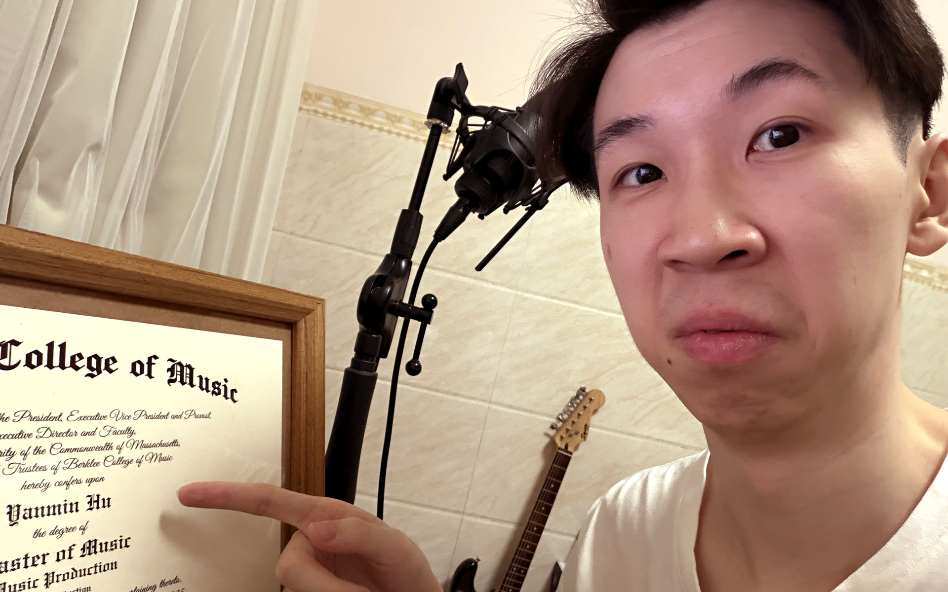 A picture of Yanmin pointing at his degree.